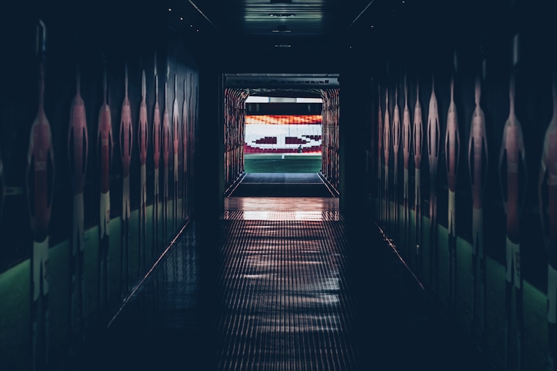 现代大型体育场馆内部全景，蓝色座椅与绿色草坪相映，灯光璀璨，充满竞技氛围